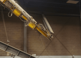 Catastrophic underhung overhead bridge crane runway fail, broken runway hanging loose from ceiling mount at metal finishing plant in central Indiana