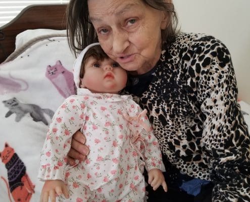 An elderly woman with a Lucys for Lynn doll