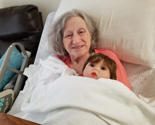 An elderly woman with a Lucys for Lynn doll