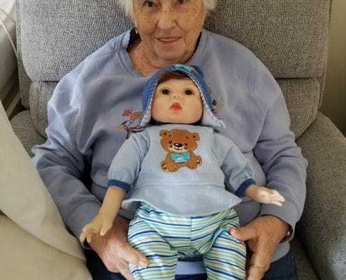 An elderly woman with a Lucys for Lynn doll